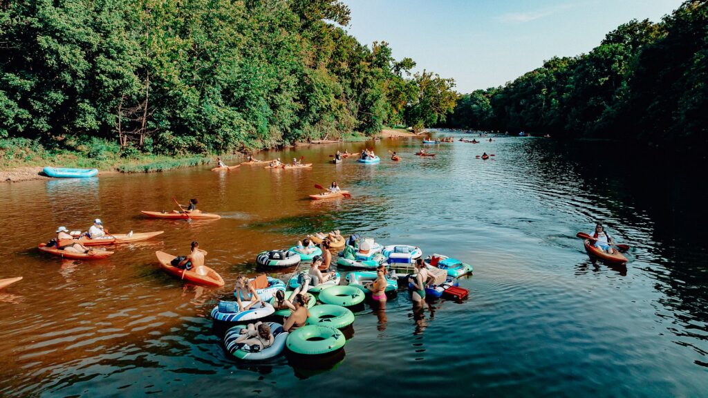 An aerial view of tubes, kayaks and rafts drifting together down the Meramec.