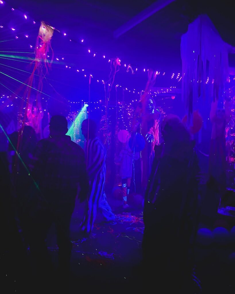 Guests walking the blacklight haunted trail after dark