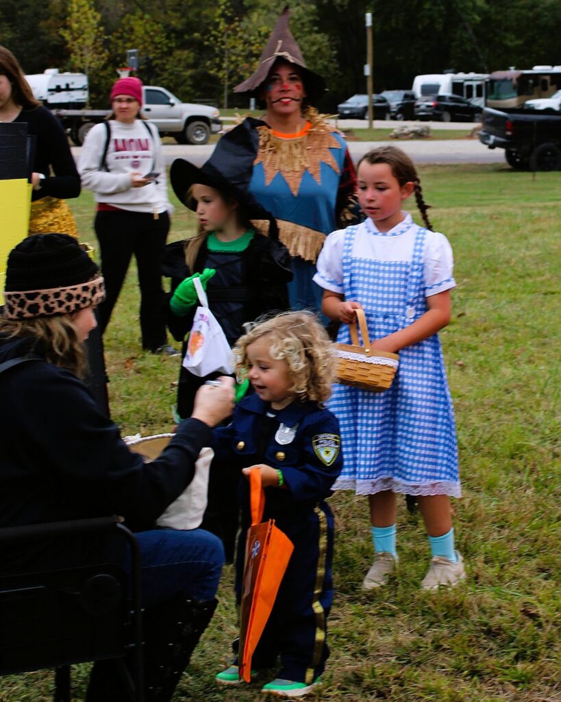 Children in costume trick-or-treating between campsites
