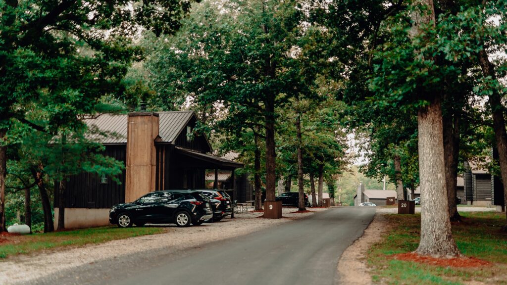A shaded road running past cabins and numbered sites through the resort grounds.