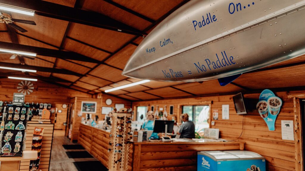 A canoe hung above the camp store counter painted 'Keep Calm, Paddle On'.