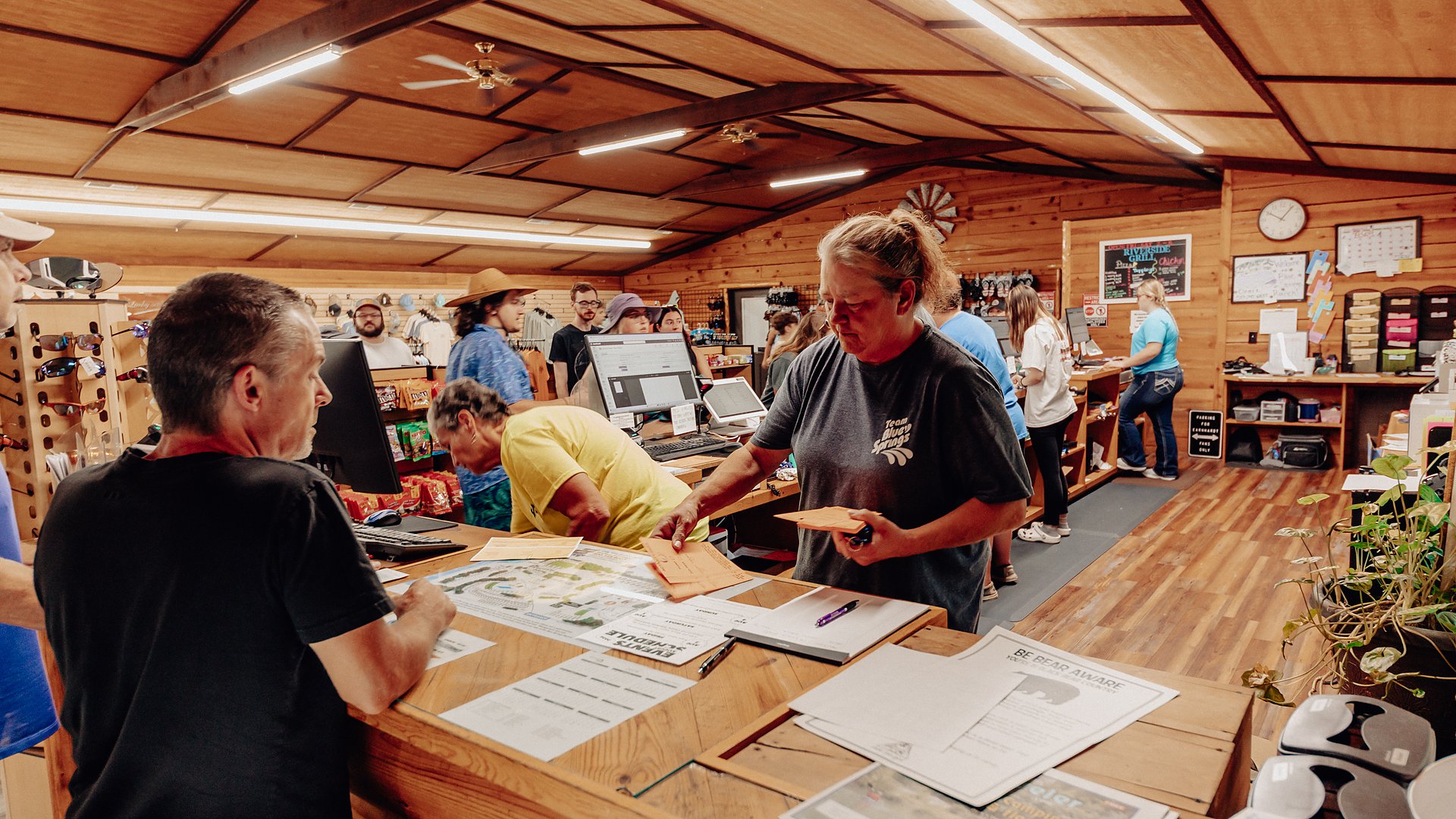 Staff helping guests at the check-in counter inside the camp store.