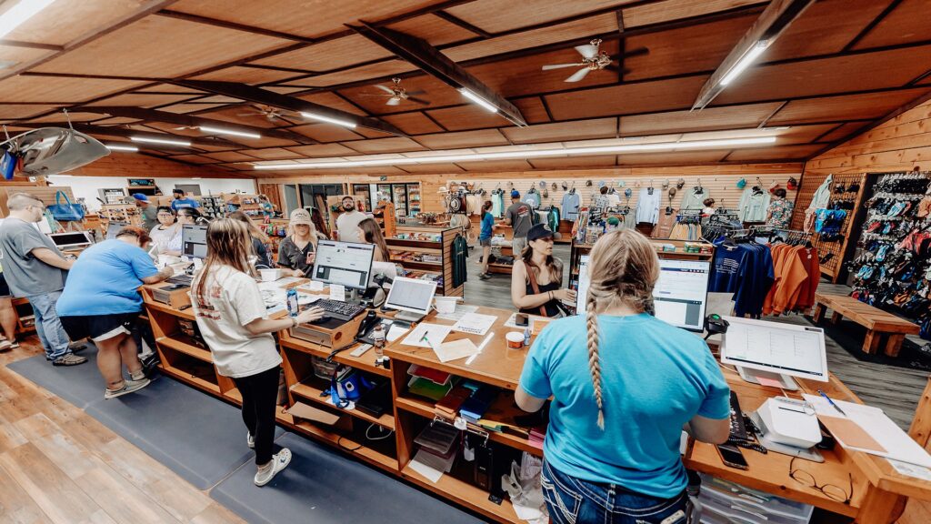 A wide view of the camp store interior with the check-in counter and merchandise racks.