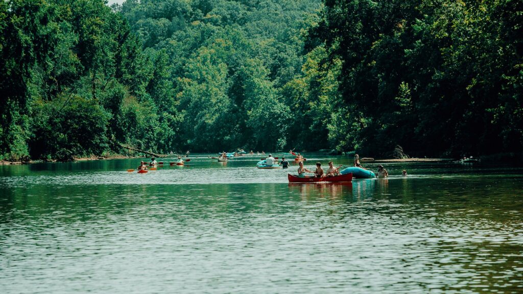 A canoe and other floaters making their way down the river.