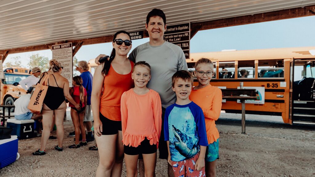 A family of five posing under the loading pavilion before their float trip.