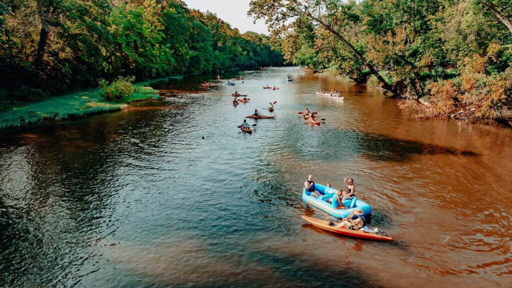 A raft and a kayak drifting side by side down the river.