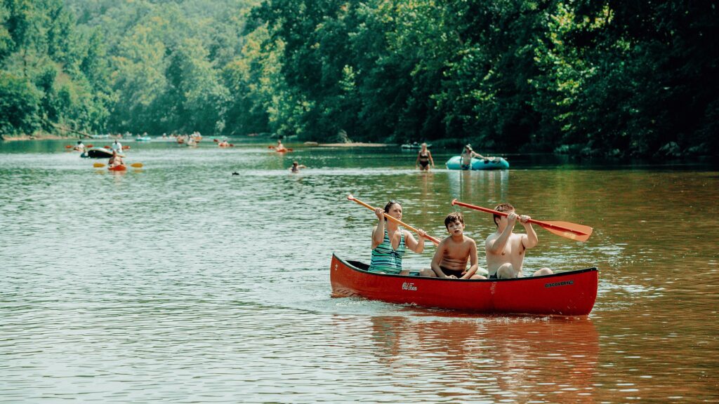 Three guests paddling a red canoe down the Meramec.