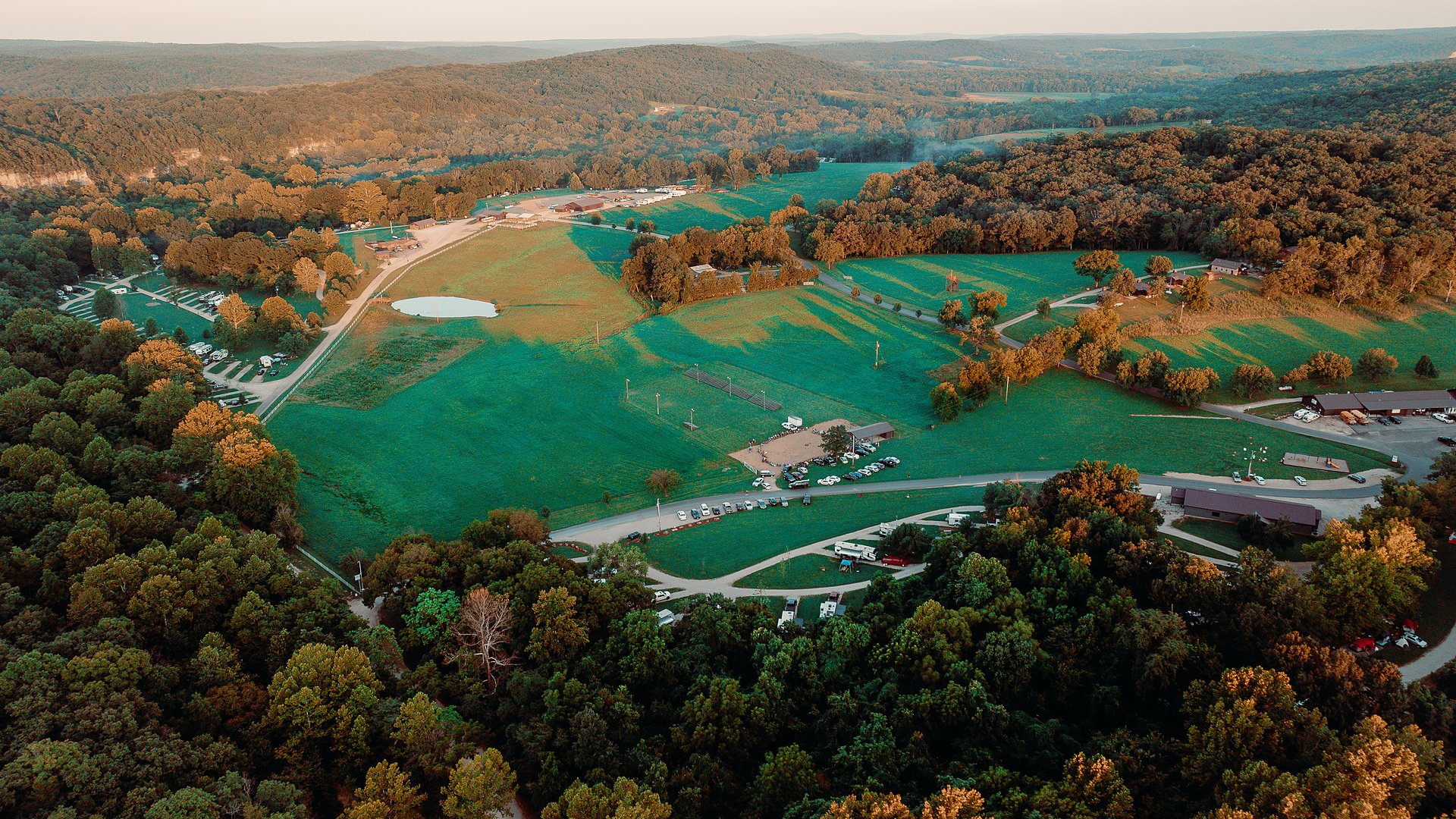 An aerial view of the resort grounds and fields with autumn colour coming in.