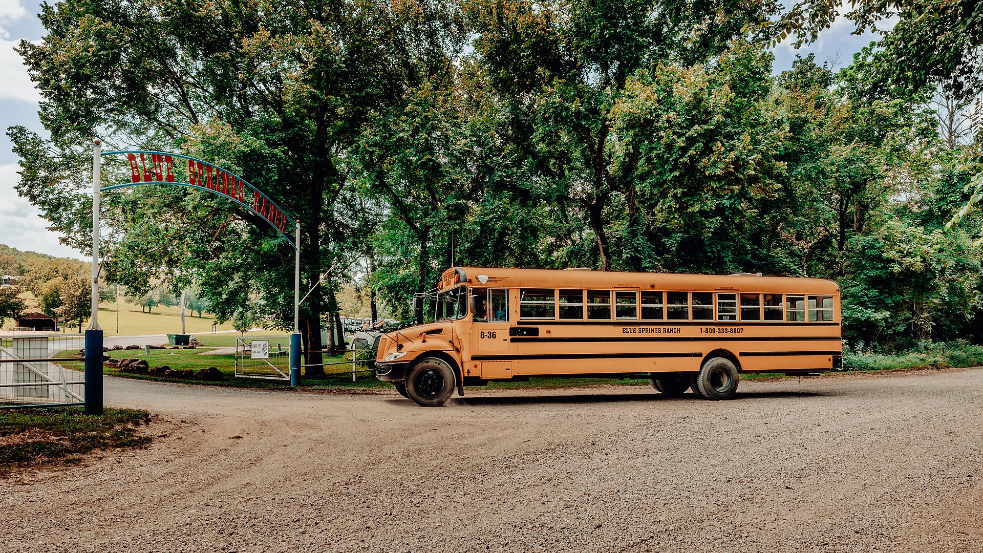 A shuttle bus beside the resort's entrance arch.