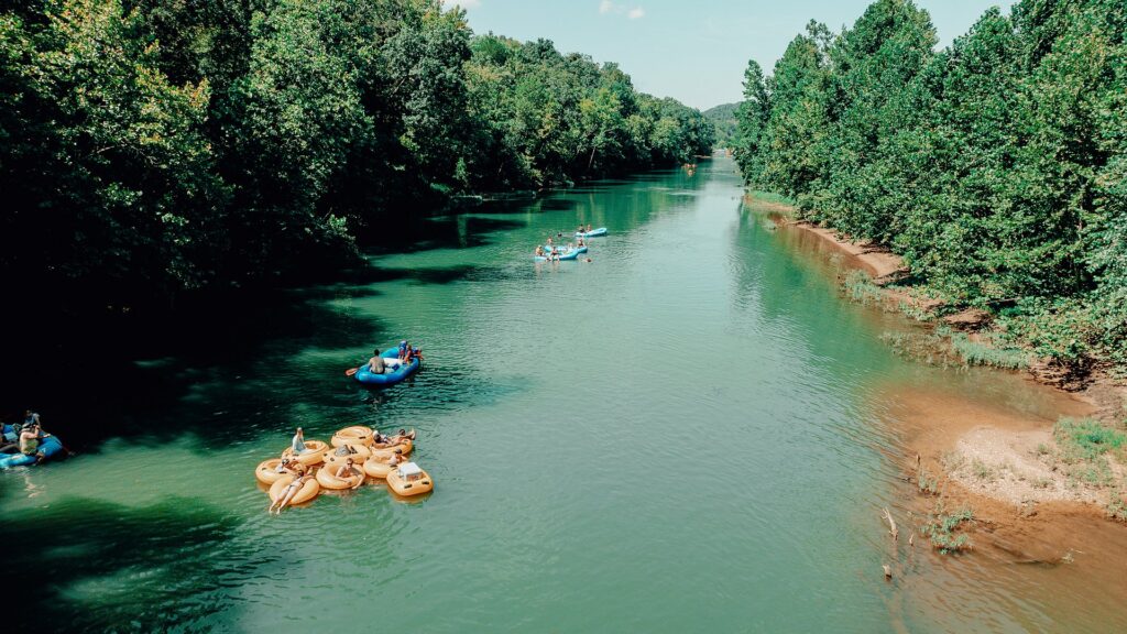 A cluster of yellow tubes tied together in the middle of the river.