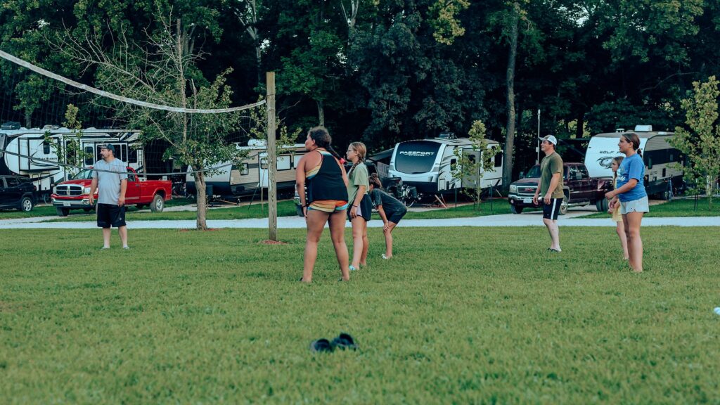 Guests gathered at the volleyball net beside the RV sites.
