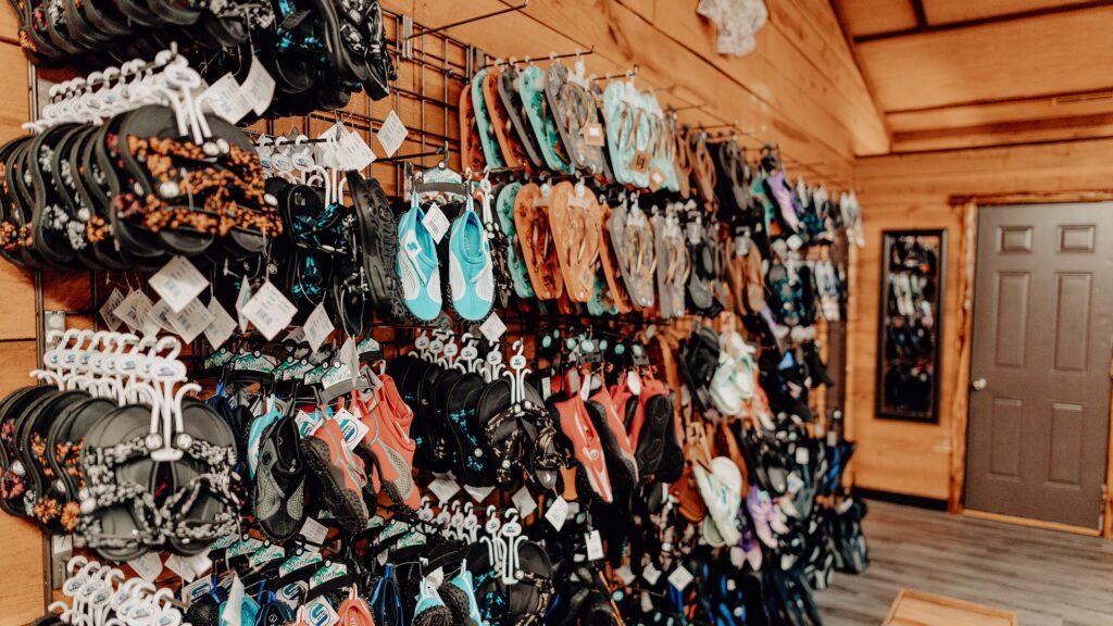 A wall of water shoes and sandals for sale in the camp store.